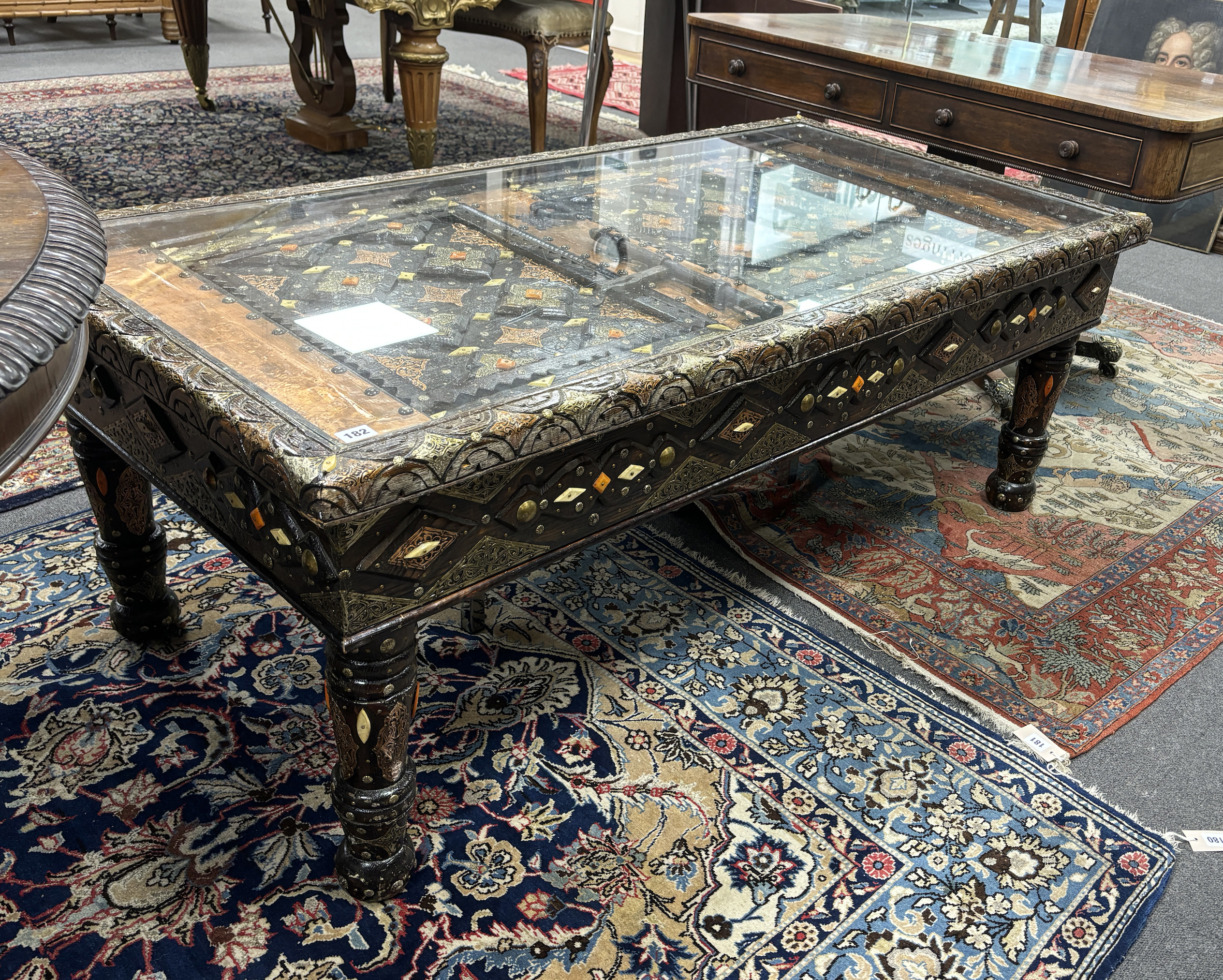 A copper mounted Moroccan door, now as a coffee table, width 153cm, depth 78cm, height 57cm